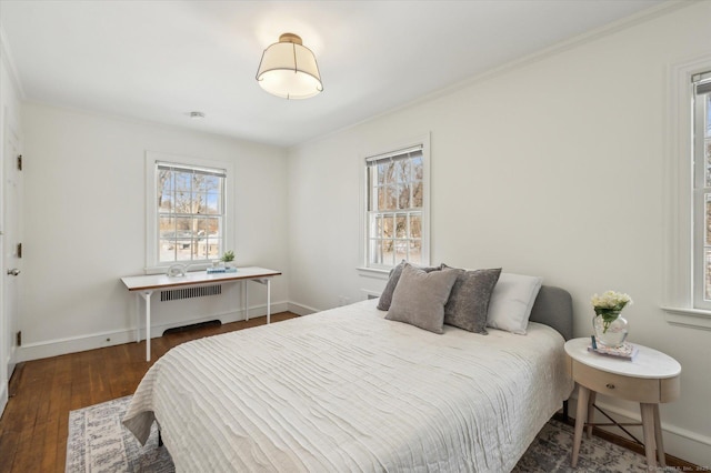 bedroom featuring radiator heating unit, crown molding, and dark wood-type flooring