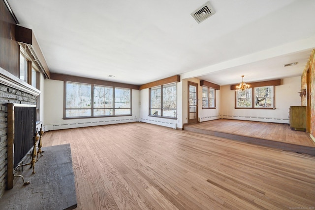 unfurnished living room with visible vents, a brick fireplace, a chandelier, baseboard heating, and wood finished floors