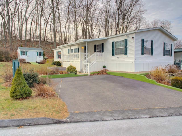 view of front of home with covered porch and a storage shed