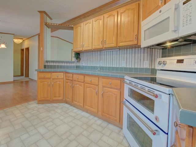 kitchen with white appliances, a chandelier, and tasteful backsplash