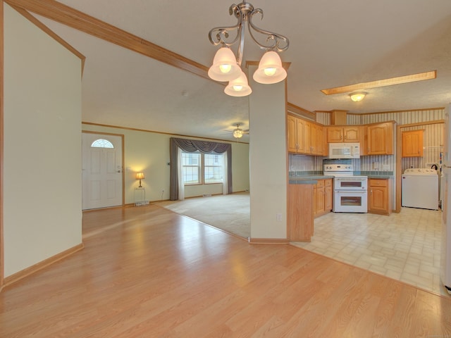 kitchen featuring double oven range, backsplash, pendant lighting, crown molding, and washer / clothes dryer