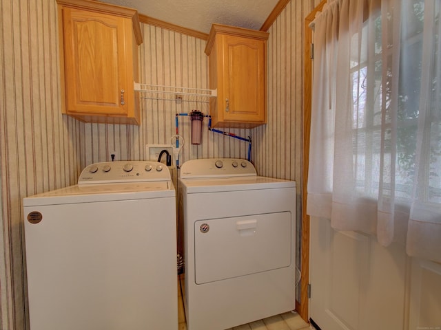 washroom featuring cabinets, a textured ceiling, and independent washer and dryer