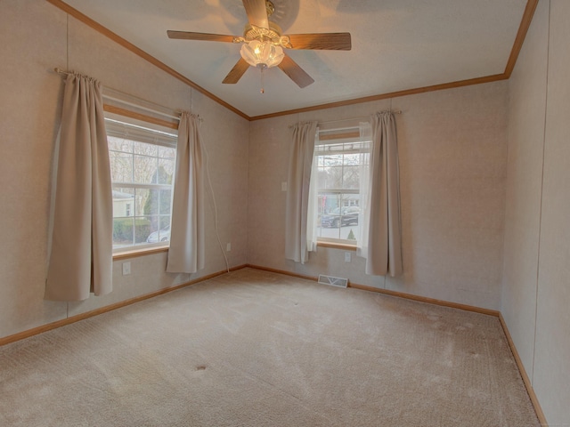 carpeted empty room with ceiling fan and crown molding