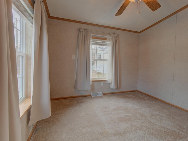 unfurnished room with ceiling fan, crown molding, and light colored carpet