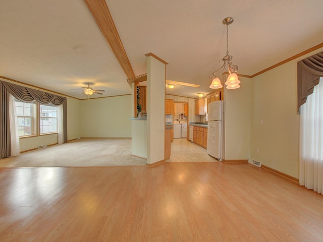 unfurnished living room with washer and dryer, light hardwood / wood-style flooring, crown molding, and ceiling fan with notable chandelier