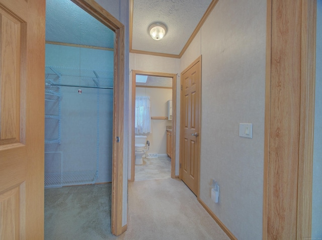 hallway featuring light carpet, ornamental molding, and a textured ceiling