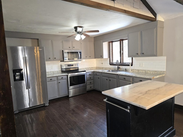 kitchen featuring sink, appliances with stainless steel finishes, gray cabinetry, dark hardwood / wood-style flooring, and kitchen peninsula