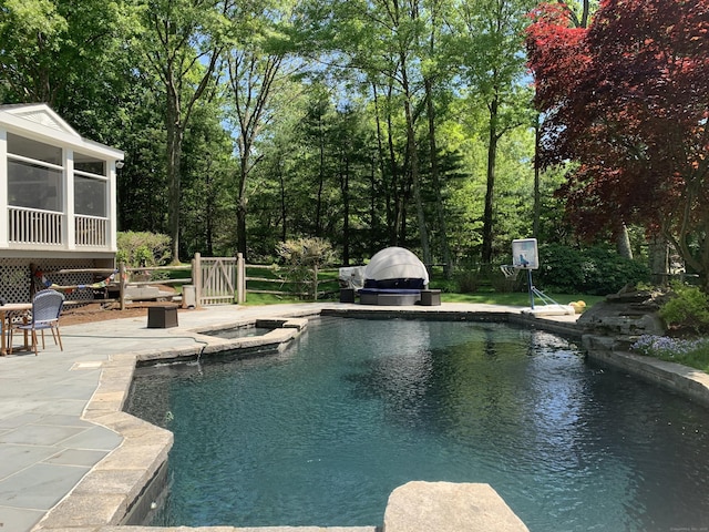 view of pool with a patio area, an outdoor fire pit, and a sunroom