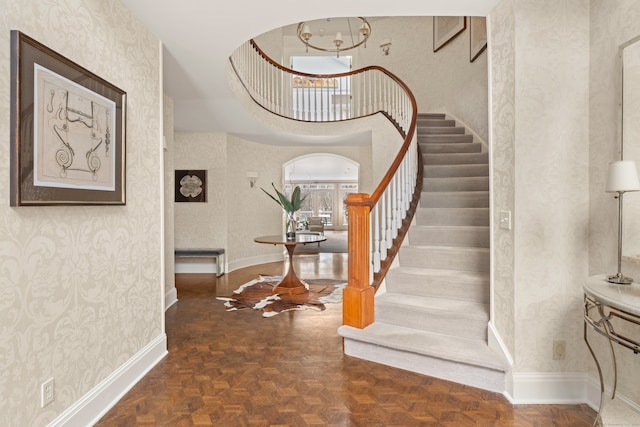 stairs with a towering ceiling and parquet floors