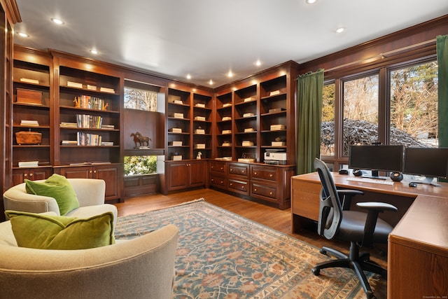 office space with light wood-type flooring and ornamental molding