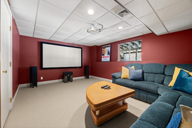 carpeted cinema with a paneled ceiling