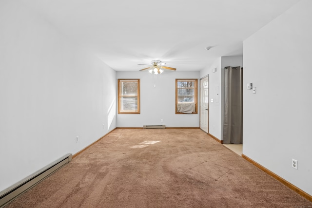 empty room featuring ceiling fan, light colored carpet, and a baseboard heating unit