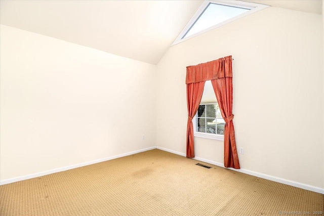 carpeted empty room with vaulted ceiling