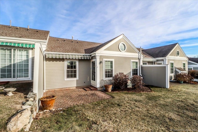 rear view of property with a patio and a lawn