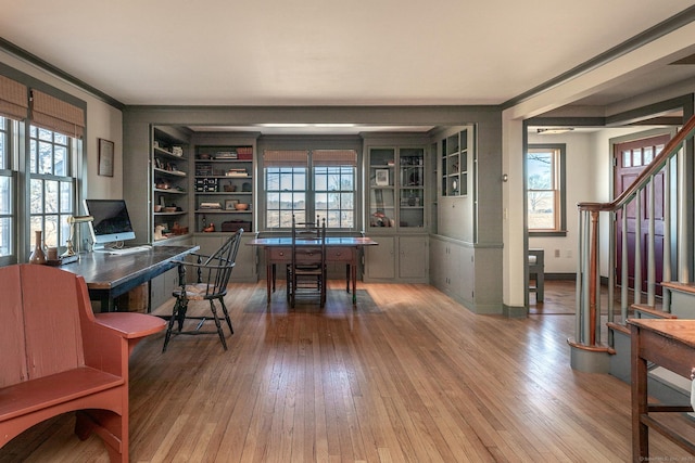 office area with a healthy amount of sunlight, wood-type flooring, and crown molding