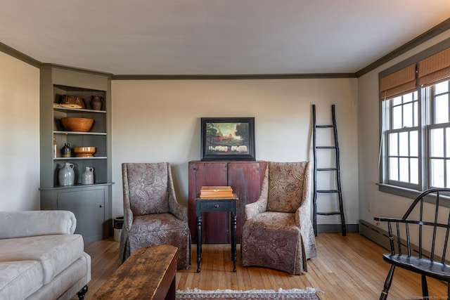 sitting room with light hardwood / wood-style floors and crown molding