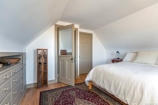 bedroom with light hardwood / wood-style flooring and vaulted ceiling