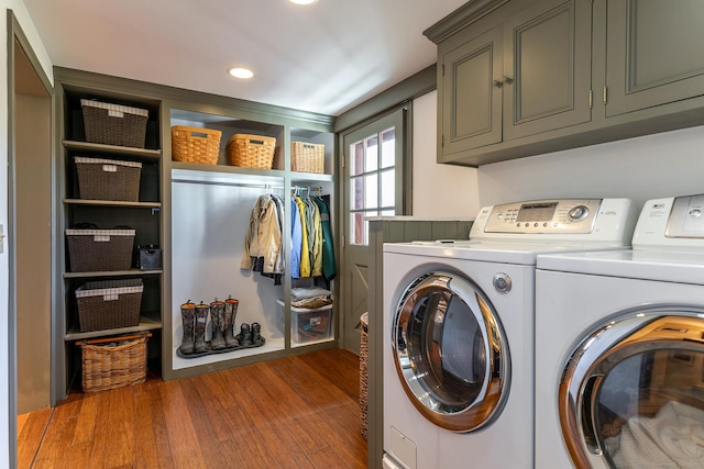 laundry room featuring cabinets, independent washer and dryer, and dark wood-type flooring