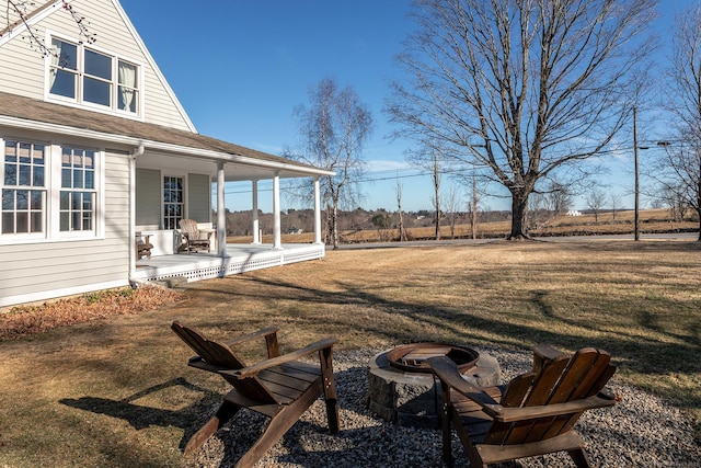 view of yard with covered porch and an outdoor fire pit