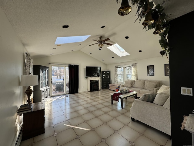 living room featuring ceiling fan, lofted ceiling with skylight, and a textured ceiling