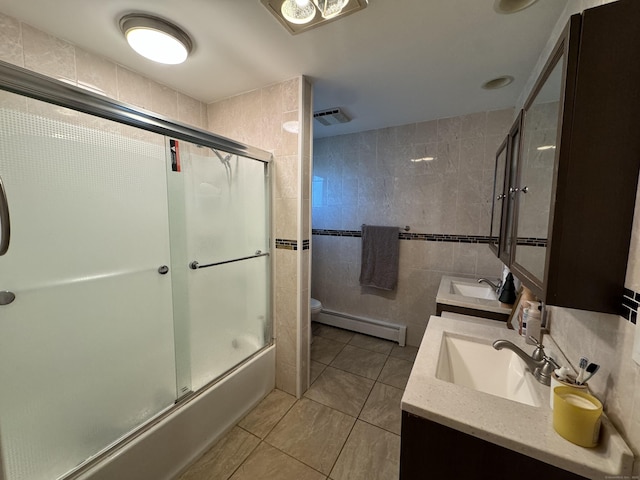 full bathroom with tile walls, enclosed tub / shower combo, vanity, baseboard heating, and toilet