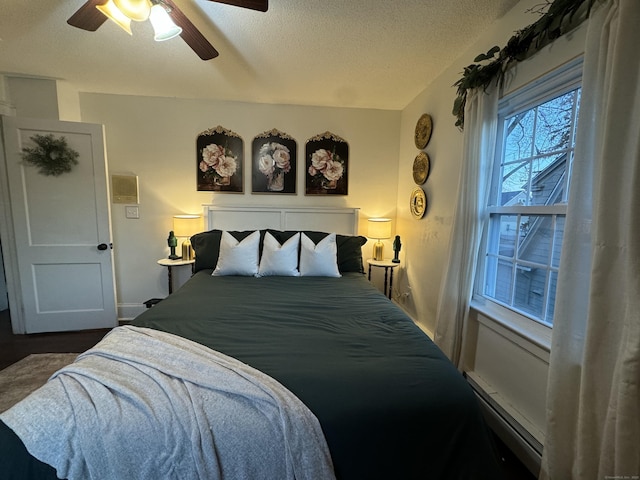 bedroom with ceiling fan, a baseboard radiator, and a textured ceiling