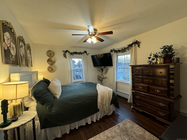 bedroom with a baseboard heating unit, dark wood-type flooring, a textured ceiling, and ceiling fan