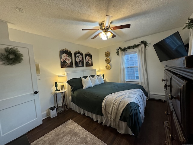 bedroom with baseboard heating, ceiling fan, dark hardwood / wood-style flooring, and a textured ceiling