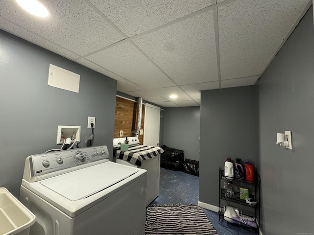 clothes washing area featuring washer / dryer, sink, and wood walls