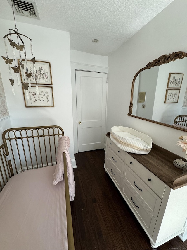 bedroom featuring dark wood-type flooring and a textured ceiling