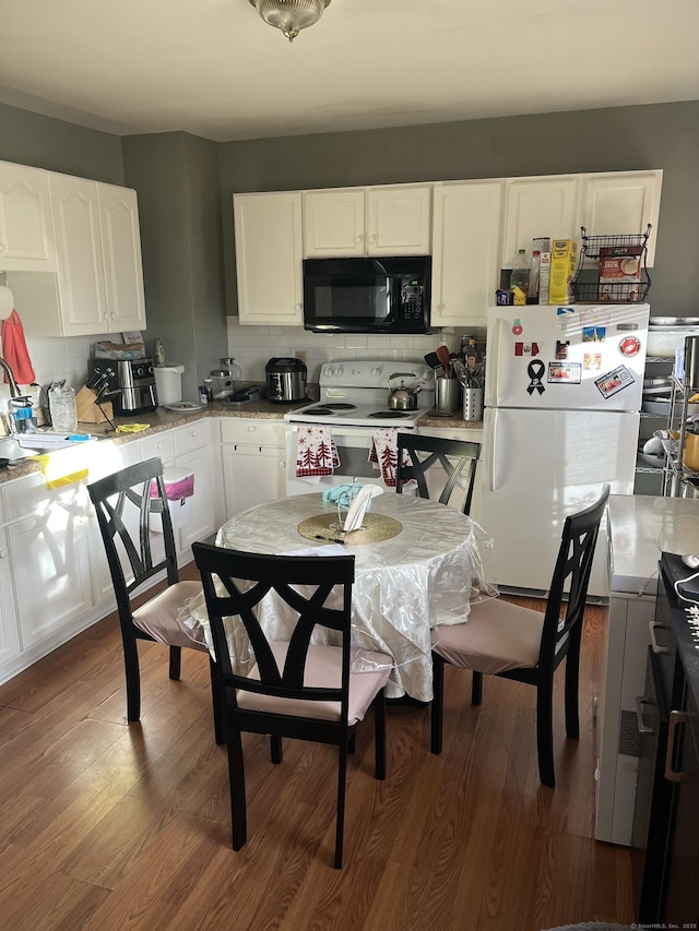 kitchen featuring white appliances, tasteful backsplash, white cabinetry, and dark wood-type flooring