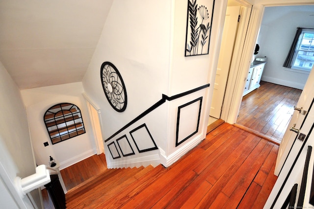 staircase with hardwood / wood-style flooring and lofted ceiling