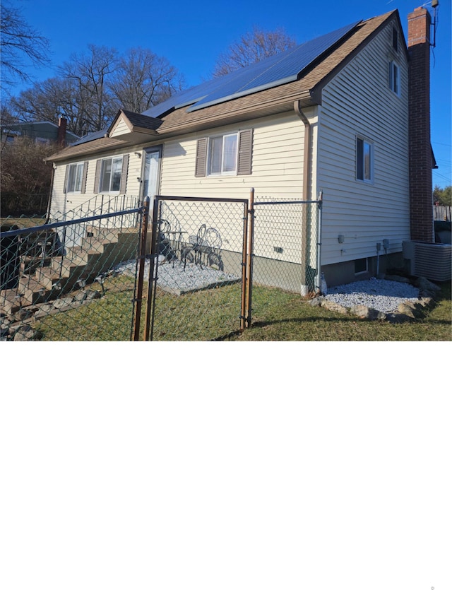 view of front facade featuring a front lawn and solar panels