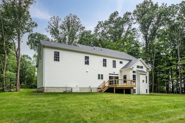 rear view of house with a wooden deck and a lawn