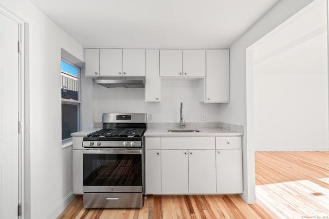 kitchen featuring light hardwood / wood-style flooring, white cabinetry, sink, and stainless steel range with gas stovetop