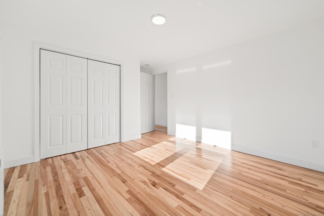 unfurnished bedroom with a closet and light hardwood / wood-style flooring