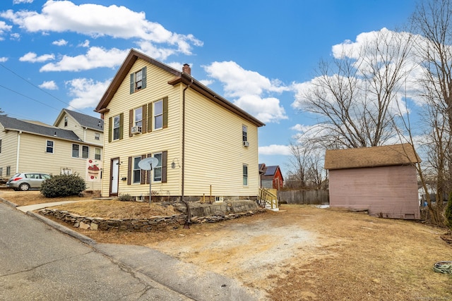 view of side of home with a storage shed