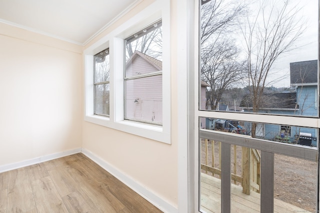 entryway with plenty of natural light, light hardwood / wood-style flooring, and ornamental molding