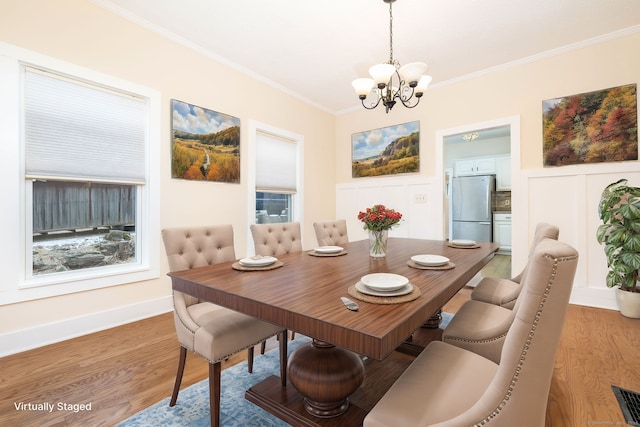 dining space featuring plenty of natural light, crown molding, a chandelier, and hardwood / wood-style flooring