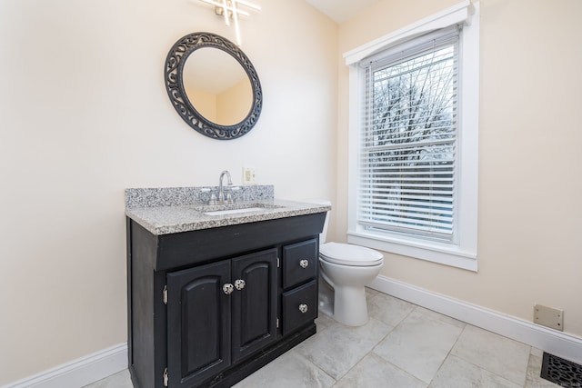 bathroom with toilet, tile patterned floors, and vanity