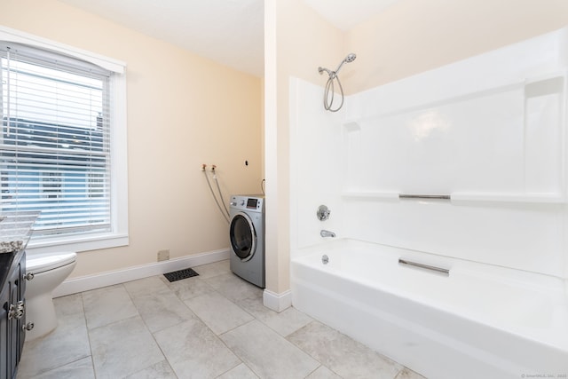 bathroom with toilet, a wealth of natural light, tile patterned floors, and washer / clothes dryer