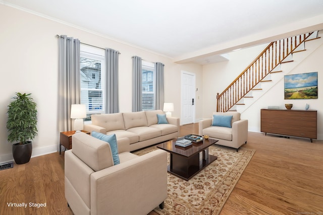 living room featuring hardwood / wood-style flooring and crown molding