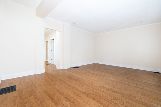 empty room with light hardwood / wood-style floors and ornamental molding