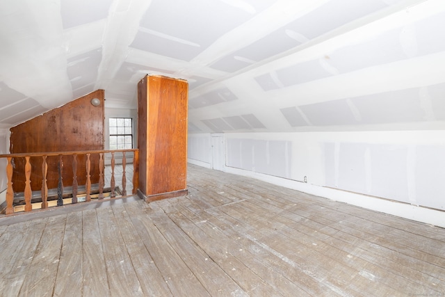 additional living space with vaulted ceiling and light hardwood / wood-style floors