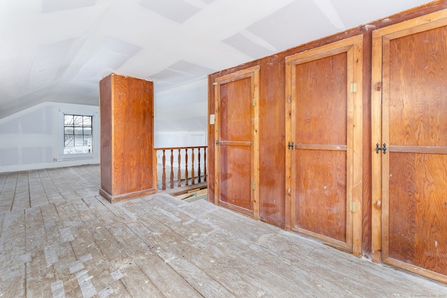 additional living space with lofted ceiling and light hardwood / wood-style floors