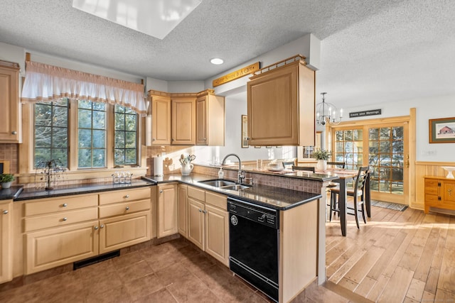 kitchen with a wainscoted wall, a sink, visible vents, decorative backsplash, and dishwasher