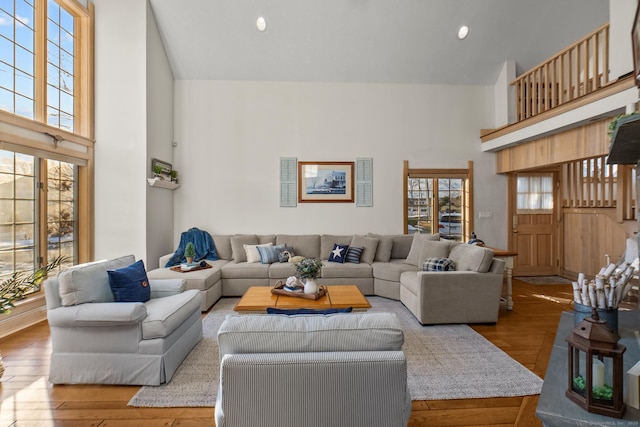 living room with hardwood / wood-style floors, a high ceiling, and a wealth of natural light