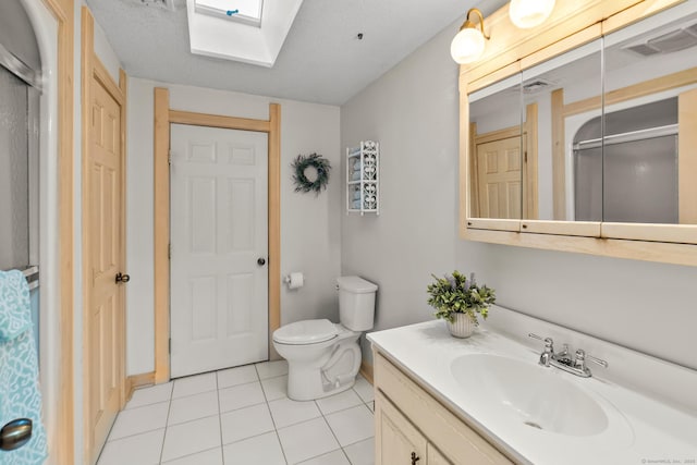 full bathroom with a skylight, visible vents, toilet, tile patterned floors, and vanity