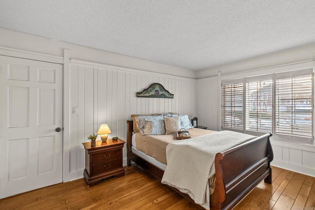 bedroom featuring light wood finished floors and a textured ceiling