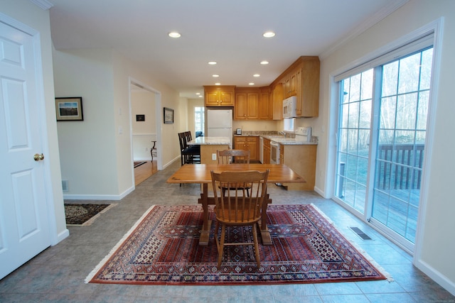 dining space featuring light tile patterned floors and ornamental molding